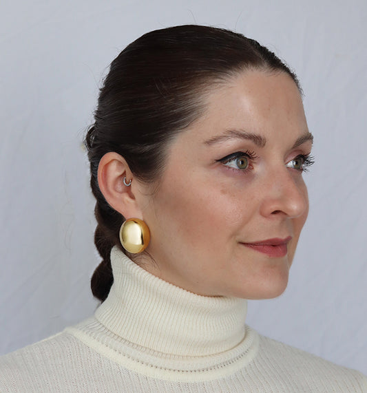 A pair of gold-colored, chunky oval dome earrings. Abi Earrings - waterproof 18K gold chunky oval dome earrings with satin finish
